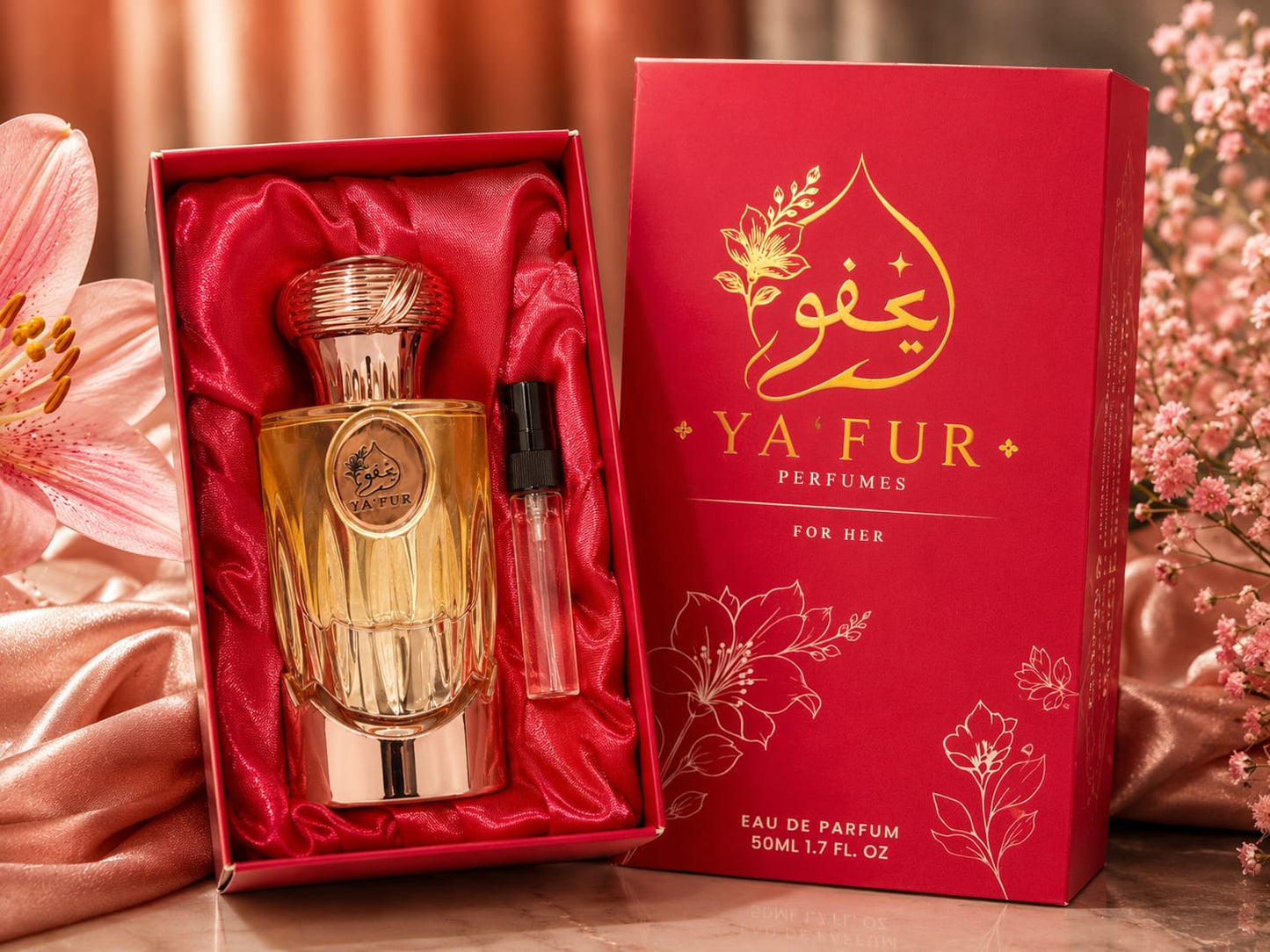 YA FUR For Her Eau de Parfum 50ml bottle in a gold-toned glass box with red satin lining, shown next to its red packaging box with gold lettering, styled with pink flowers and satin fabric.